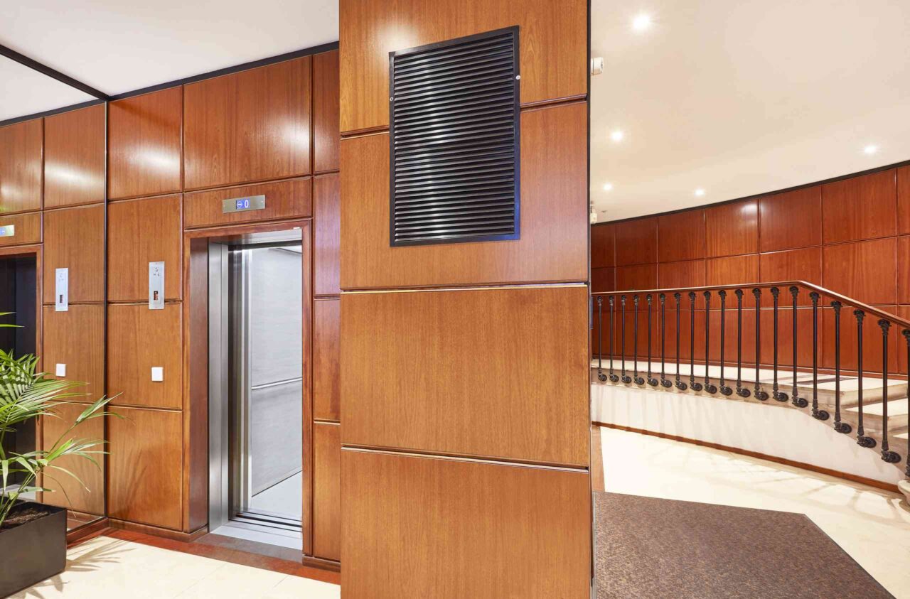 Interior with elevators, stairs, and wooden paneling.
