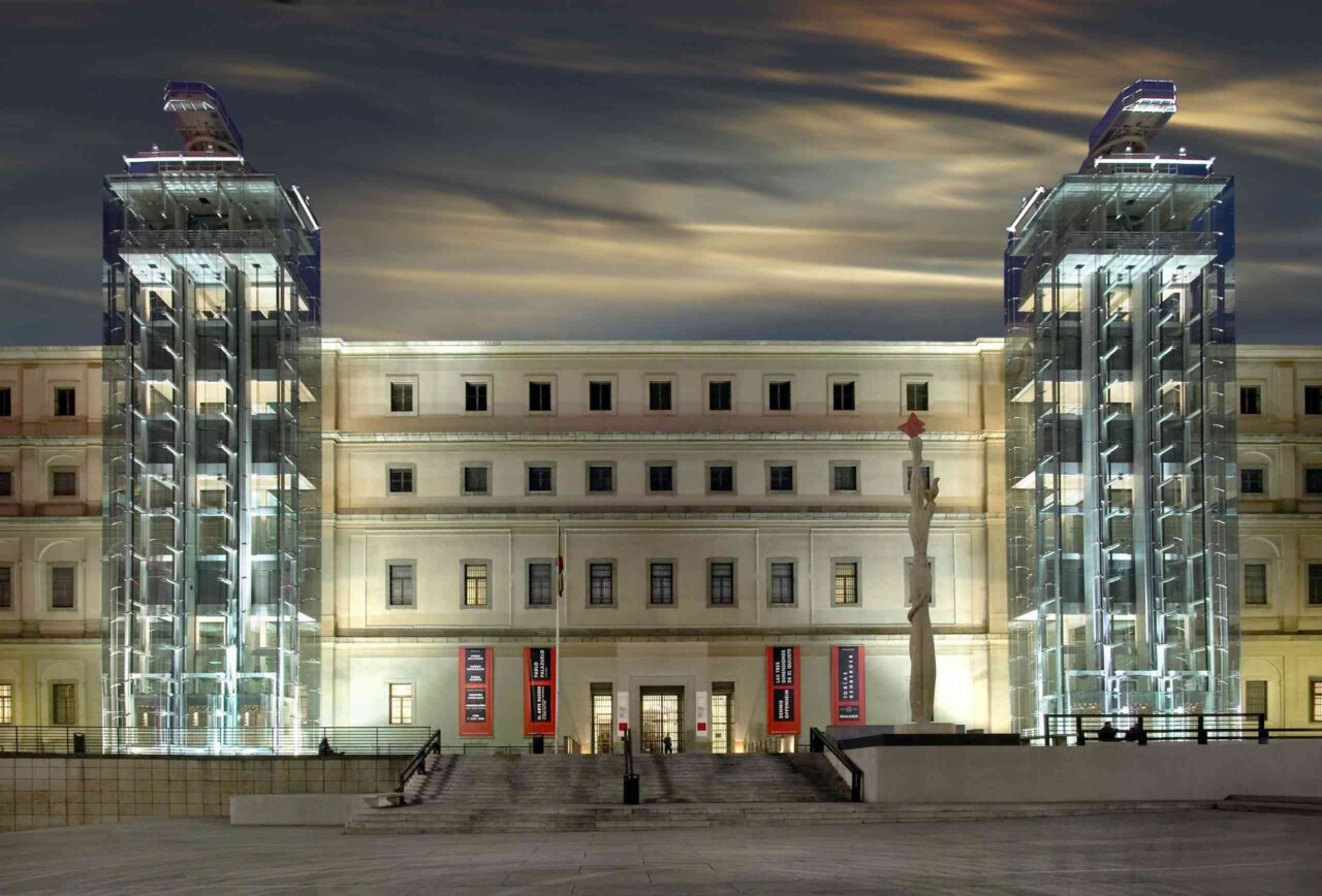 Illuminated modern building with two glass towers.